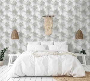 מיטה עם סדינים וכריות לבנים בחדר עם טפטים של עצי דקל