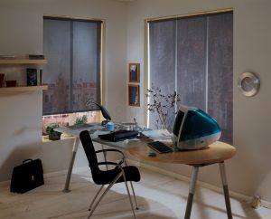 שולחן עבודה עם מחשב וכיסא בחדר עם חלונות