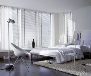 חדר שינה עם מיטה לבנה ושטיח לבן