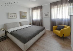 חדר שינה עם מיטה וכיסא צהוב
